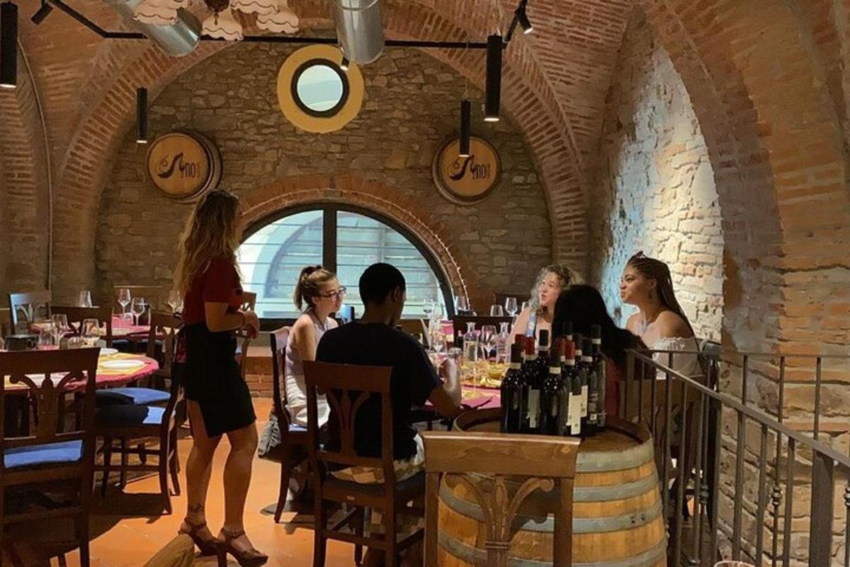 skupina lidí sedících u stolu ve vinném sklepě