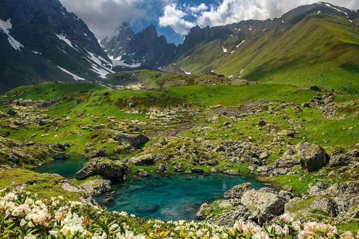 una valle di montagna con una pozza d'acqua blu