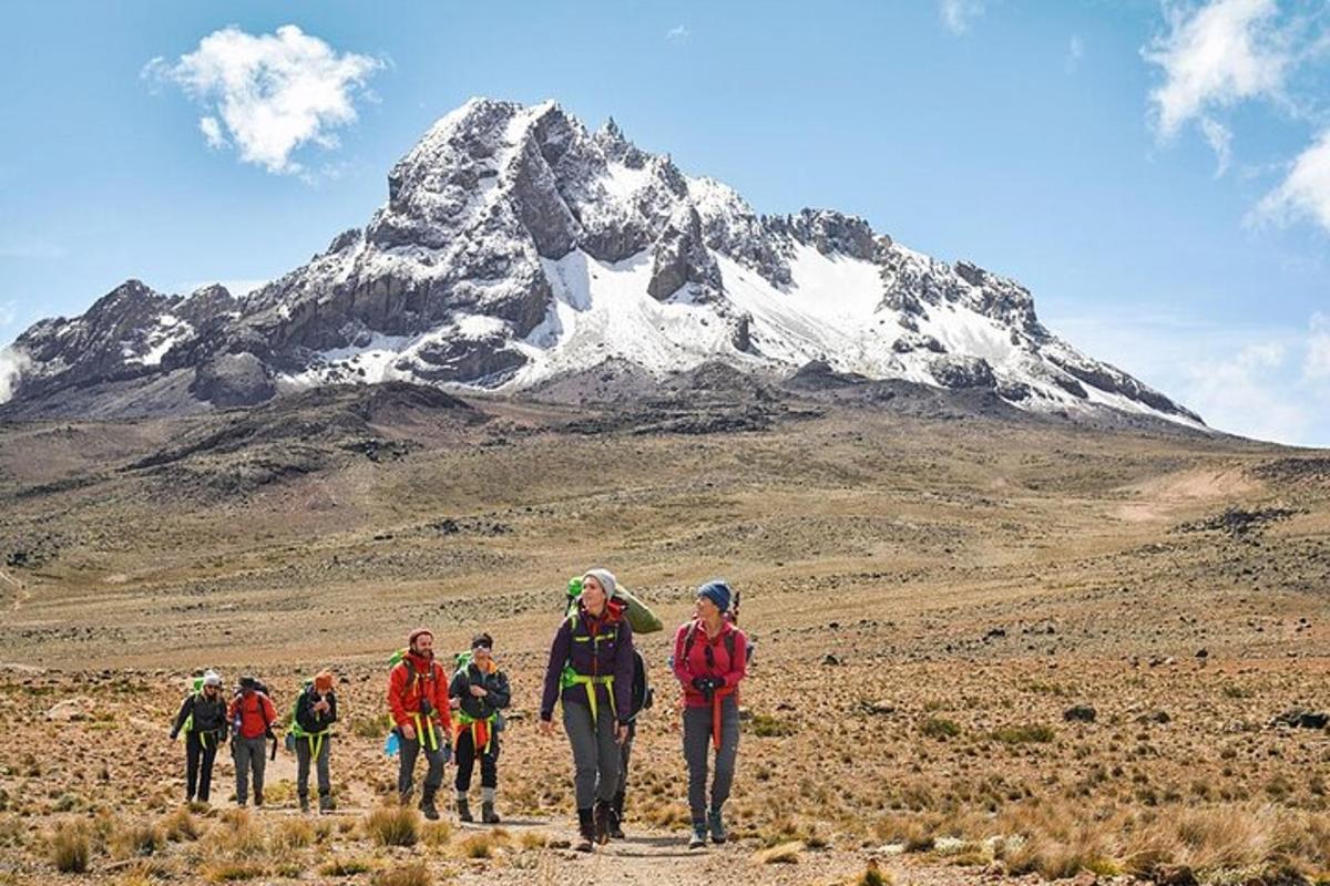 um grupo de pessoas caminhando em frente a uma montanha