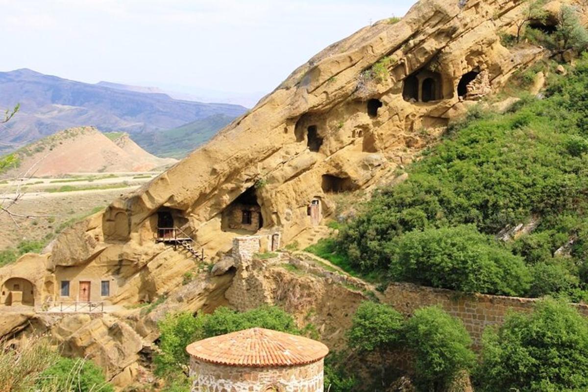 un edificio su una collina rocciosa con una montagna
