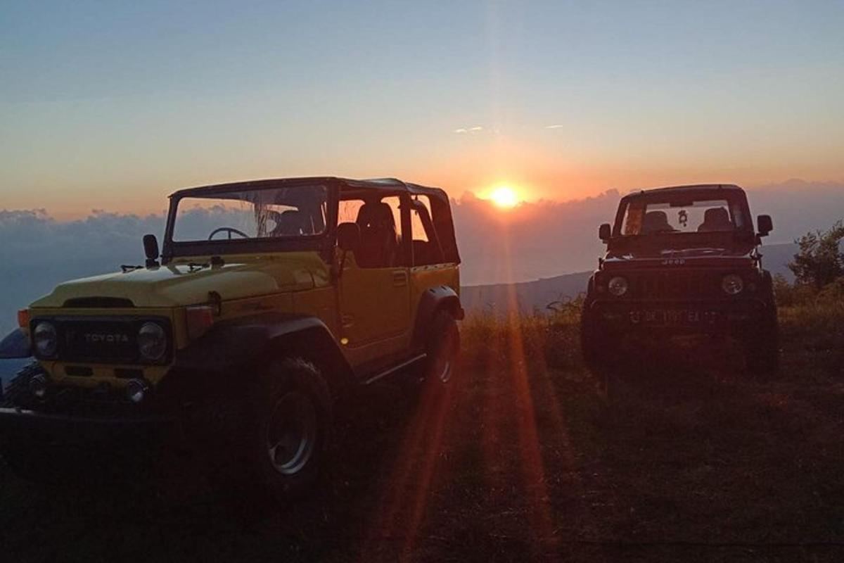Dos jeepneys estacionados en un camino de tierra al atardecer