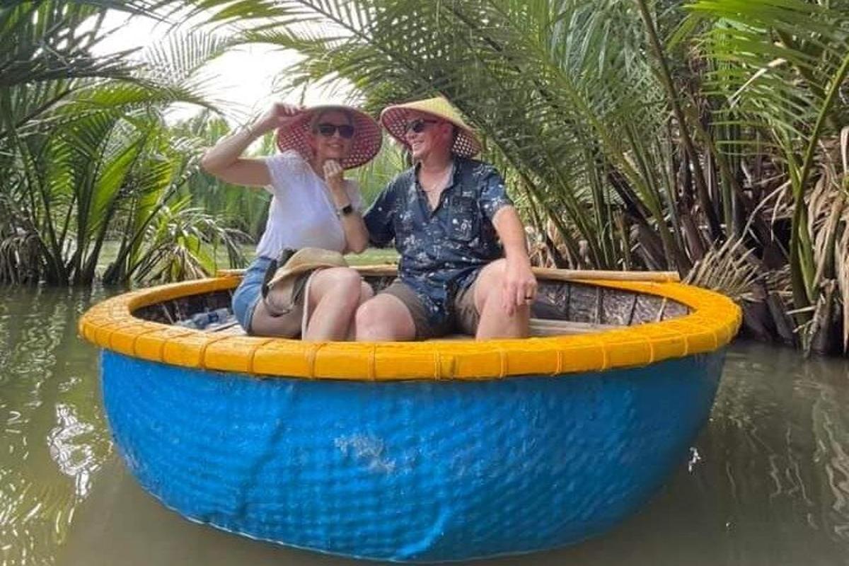Dos mujeres sentadas en un bote azul y amarillo en el agua