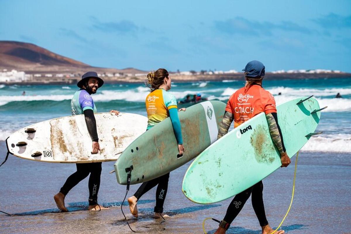 three surfers walking on the beach with their surfboards