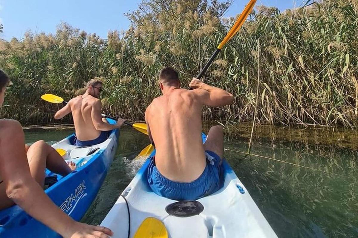 dva muži jedoucí na kajacích po řece