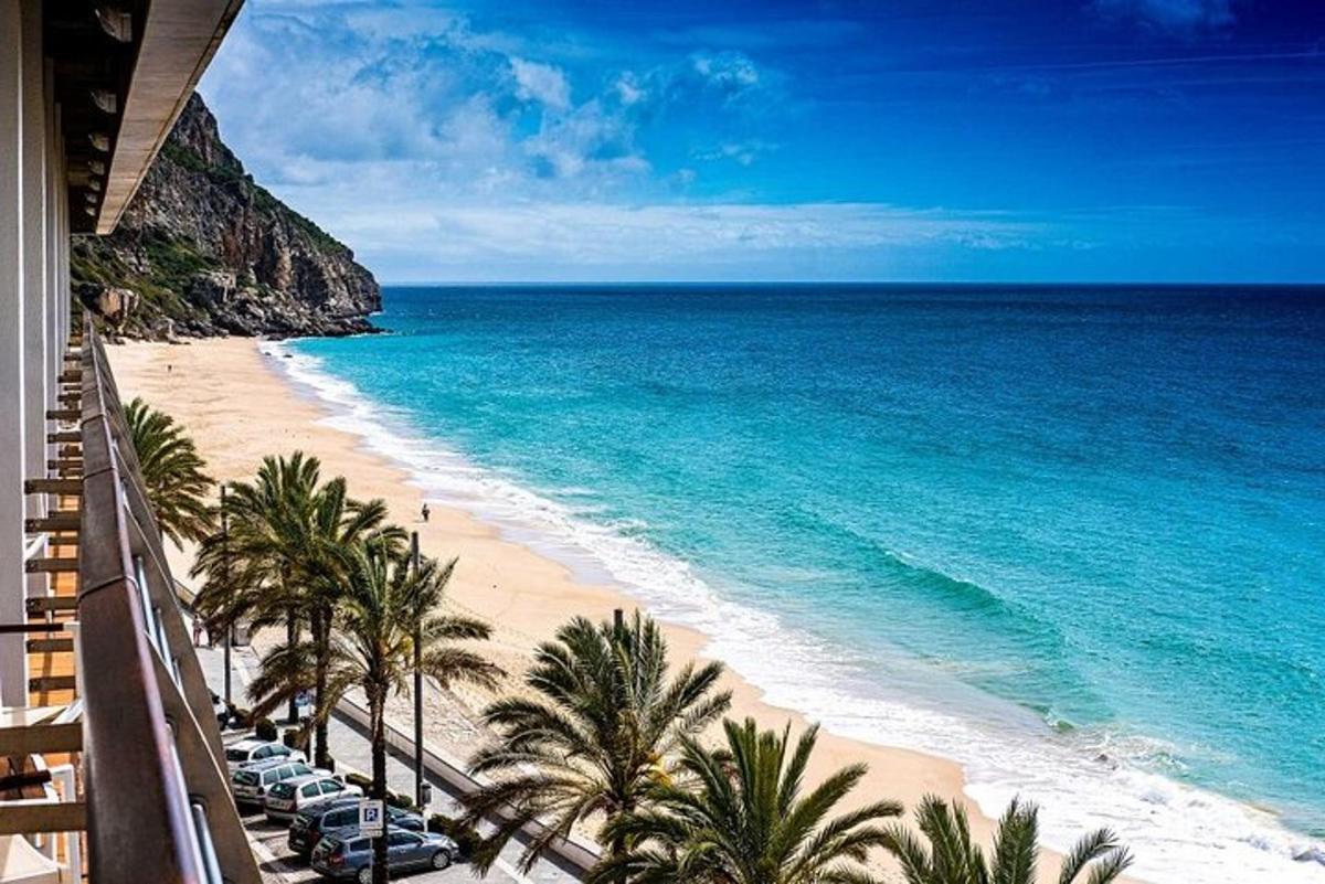 una spiaggia con sedie e palme e l'oceano