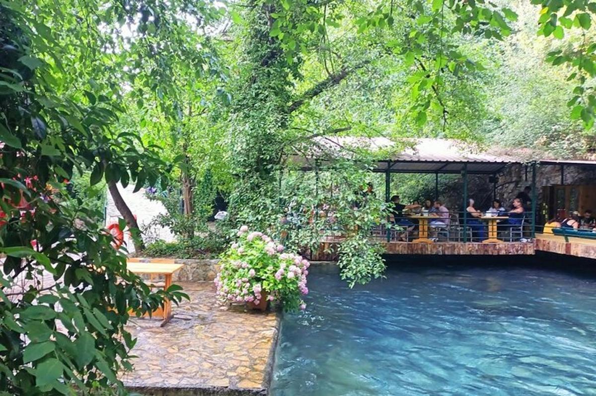 a group of people sitting at a restaurant next to a river