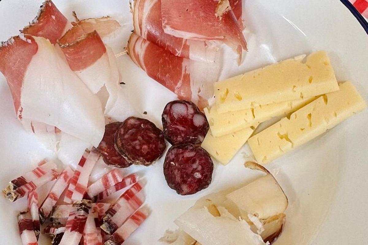 a white plate with different types of cheese and fruit