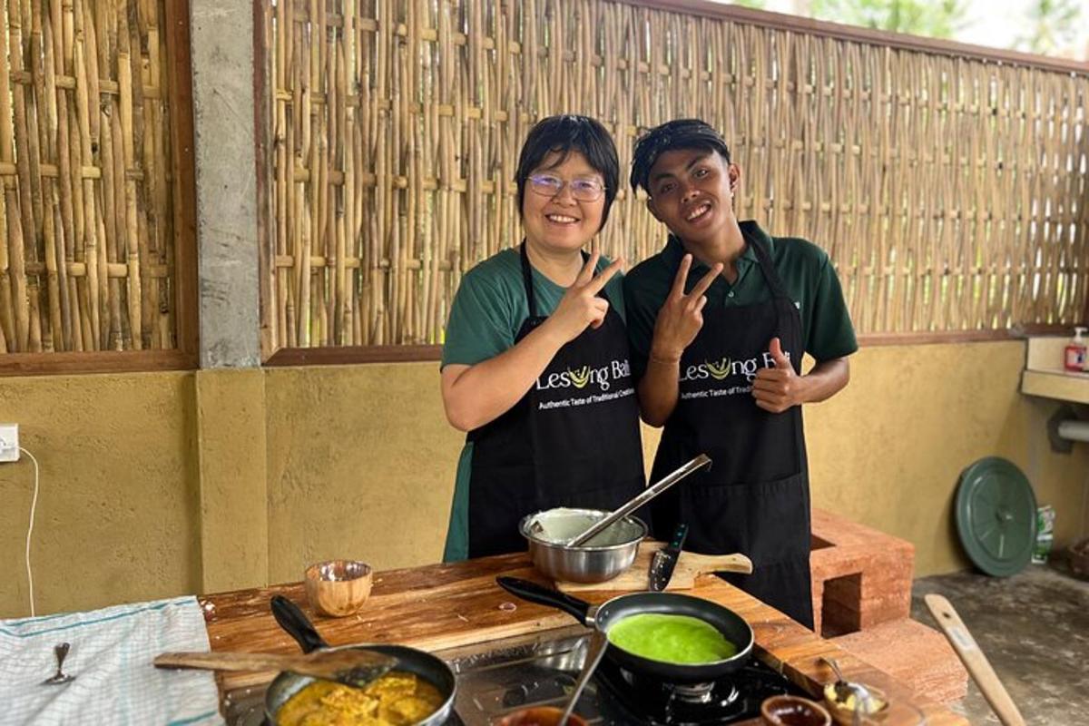 two people standing in a kitchen giving the peace sign