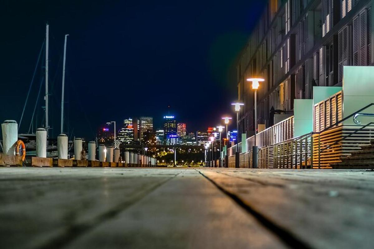 una strada vuota di notte con una città sullo sfondo