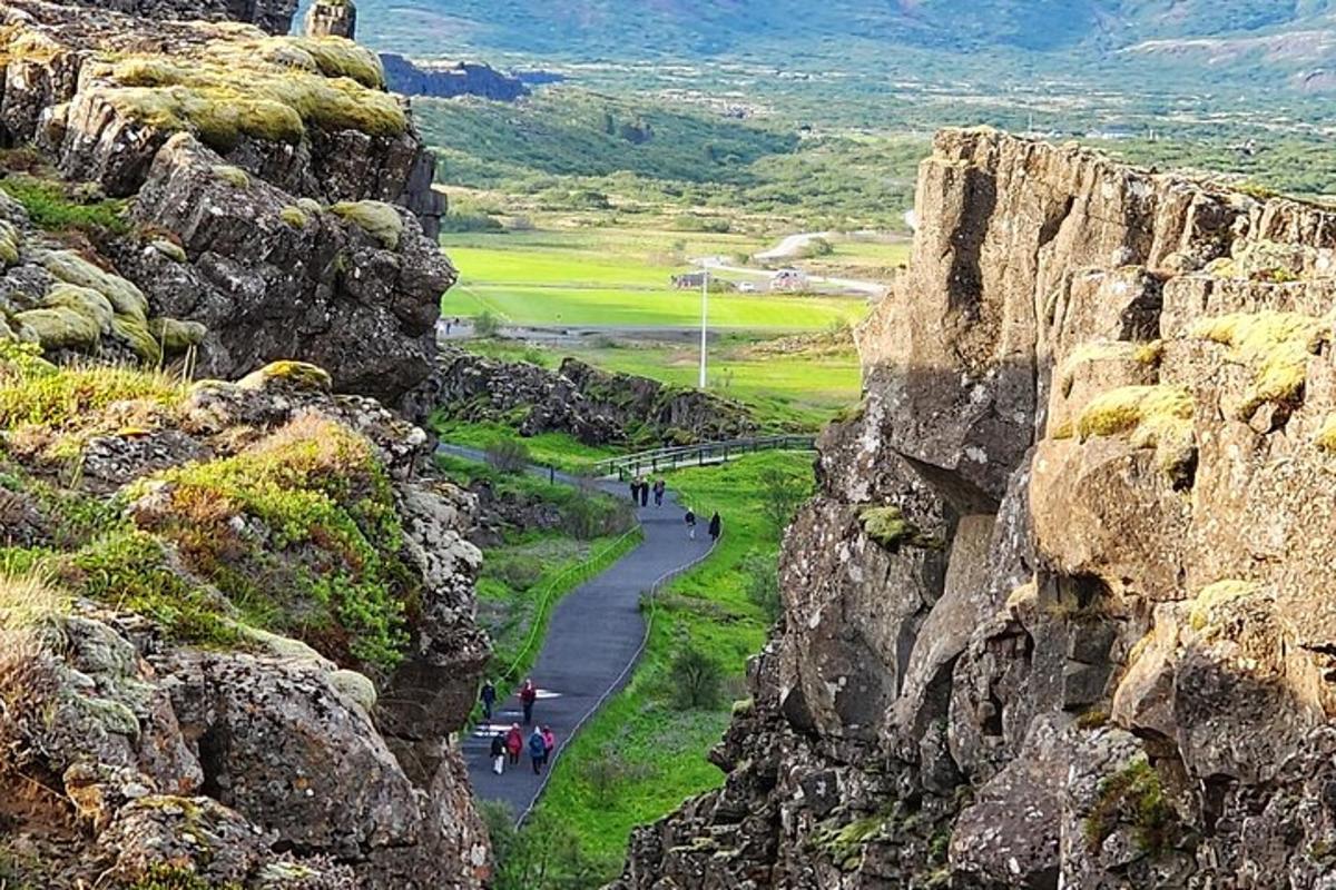 un grup de persones caminant per un camí entre roques