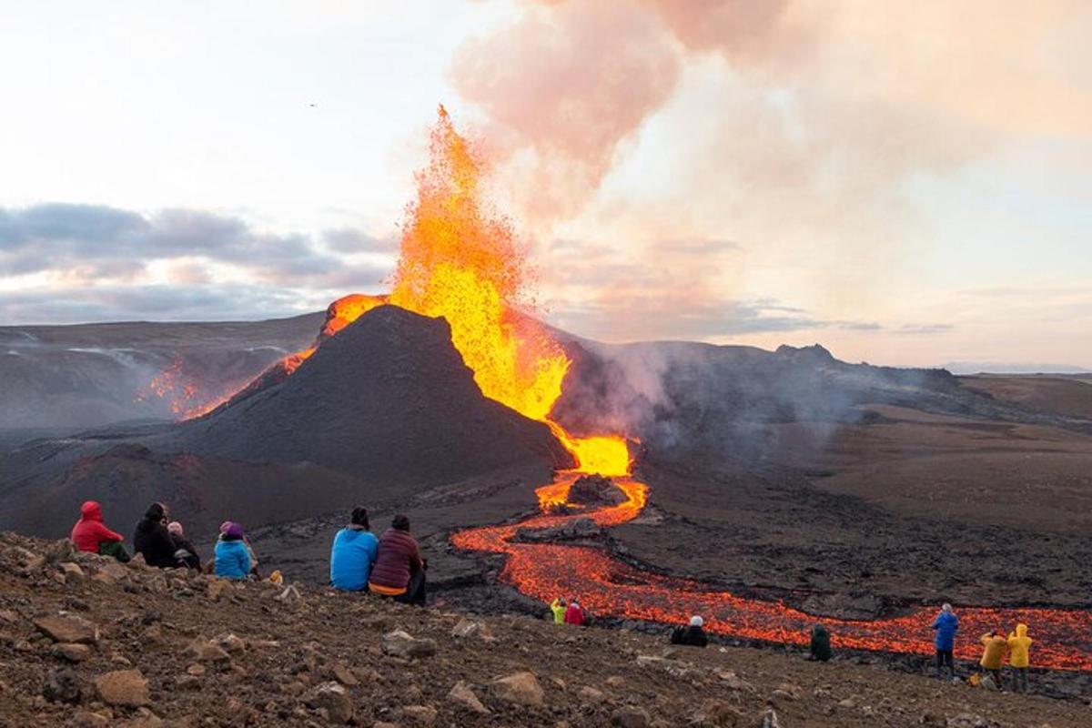 um grupo de pessoas assistindo à erupção de um vulcão
