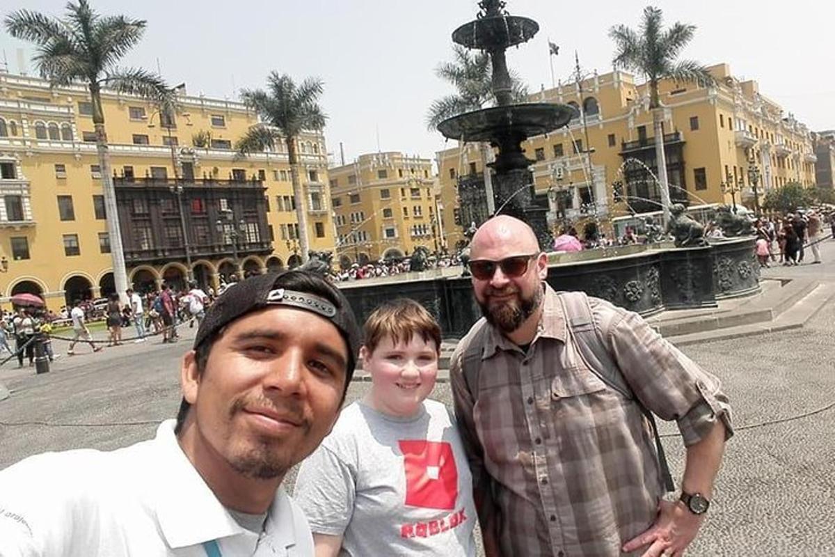 Dos hombres y un niño de pie frente a una fuente.