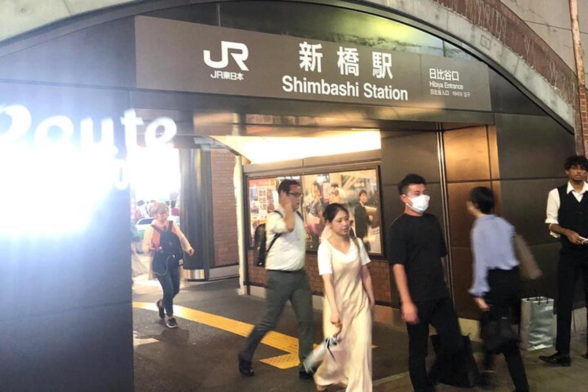 un gruppo di persone che camminano fuori da una stazione della metropolitana