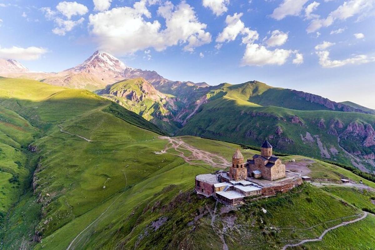 starý hrad na kopci s horami v pozadí