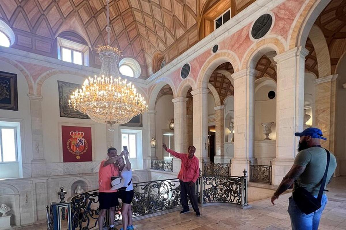 skupina lidí stojících ve vstupní hale s lustrem