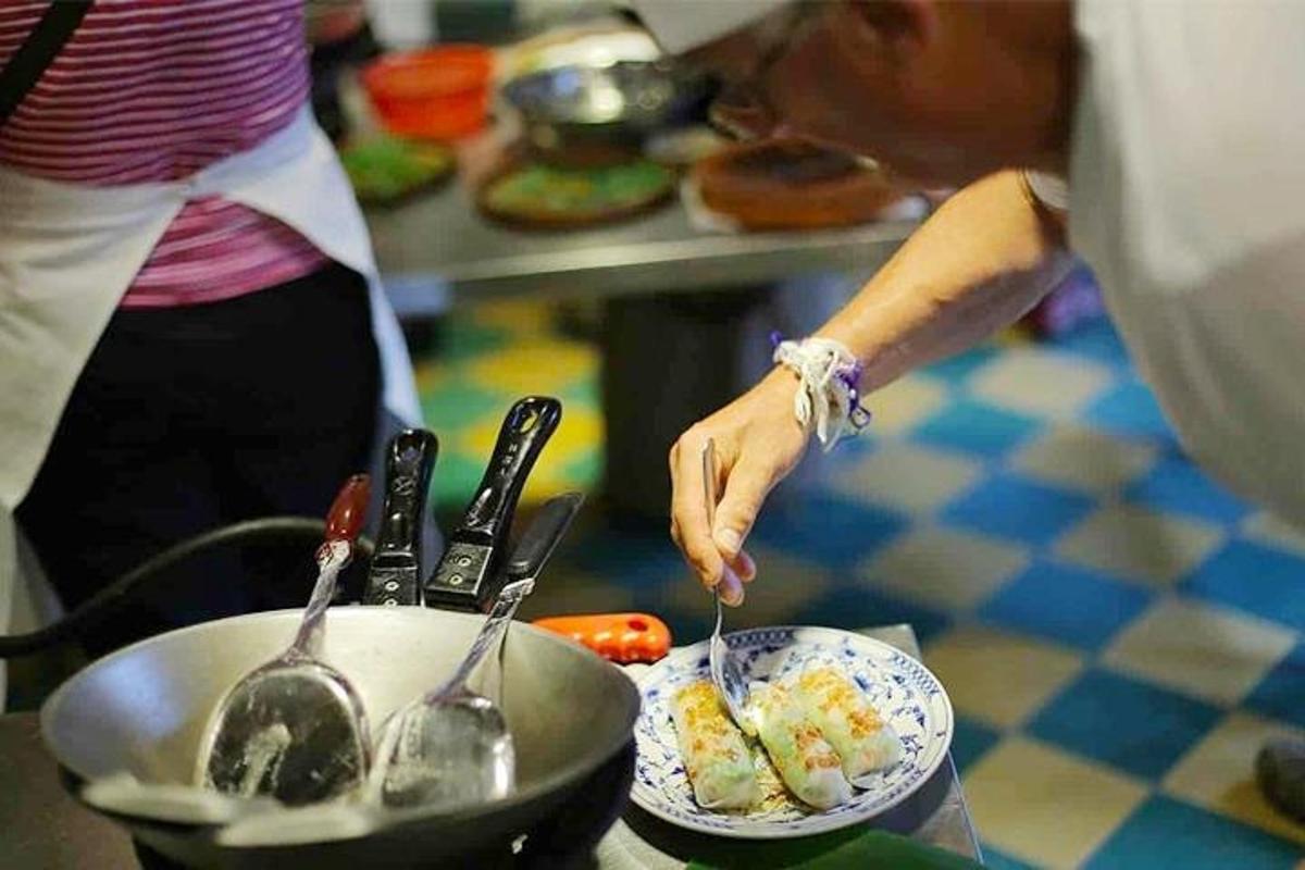 isang taong kumakain ng pagkain sa kusina na may mga kutsara