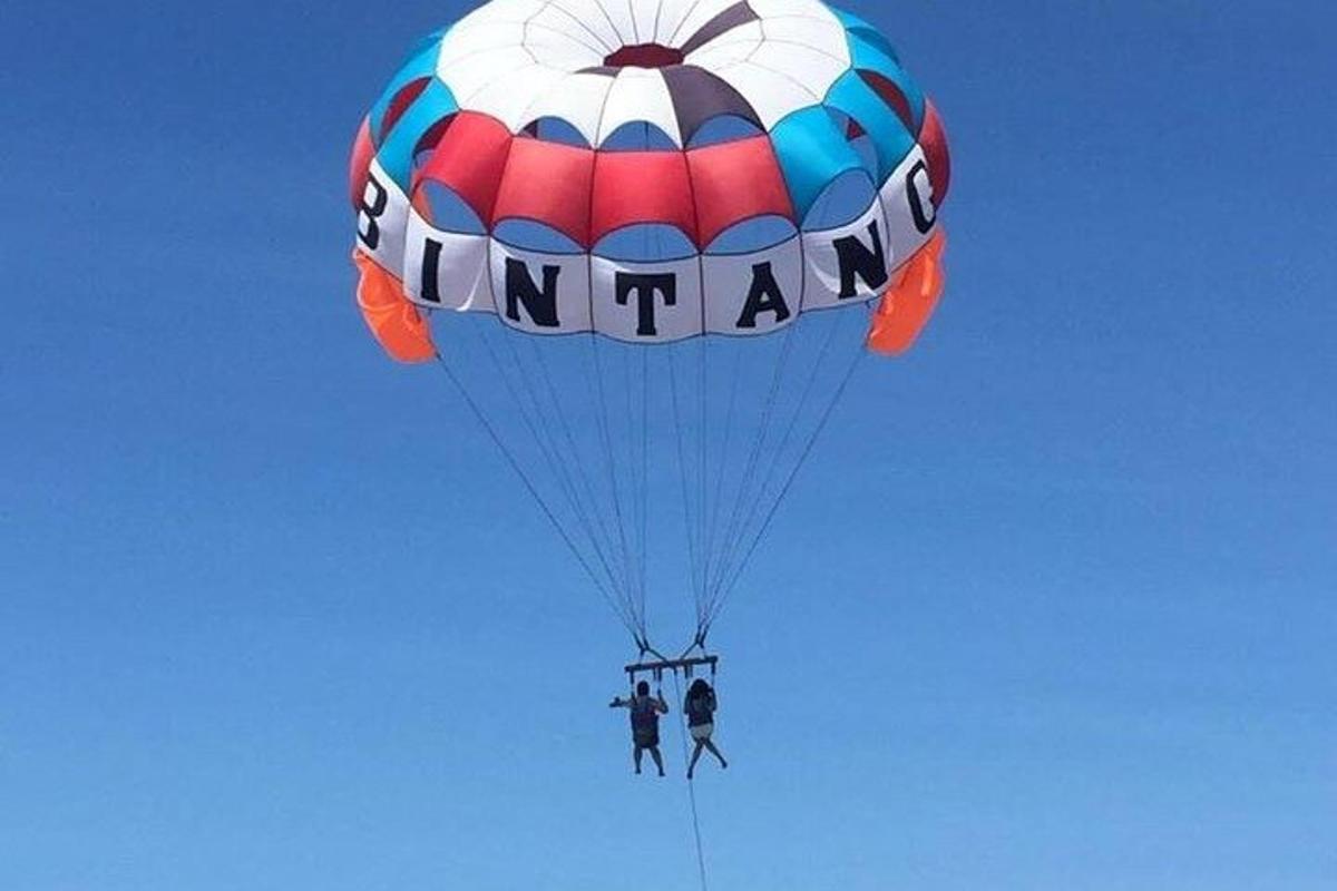 two people are riding a parachute in the sky