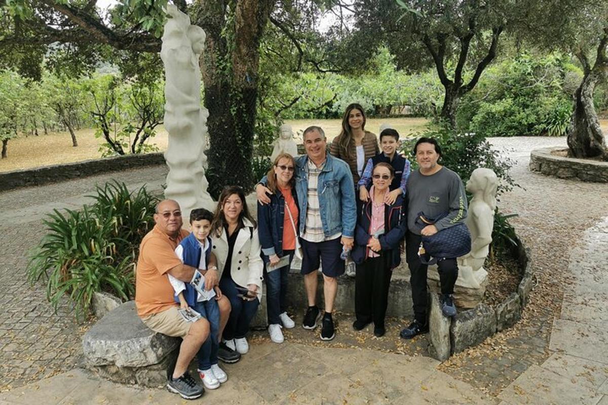 um grupo de pessoas posando em frente a uma estátua
