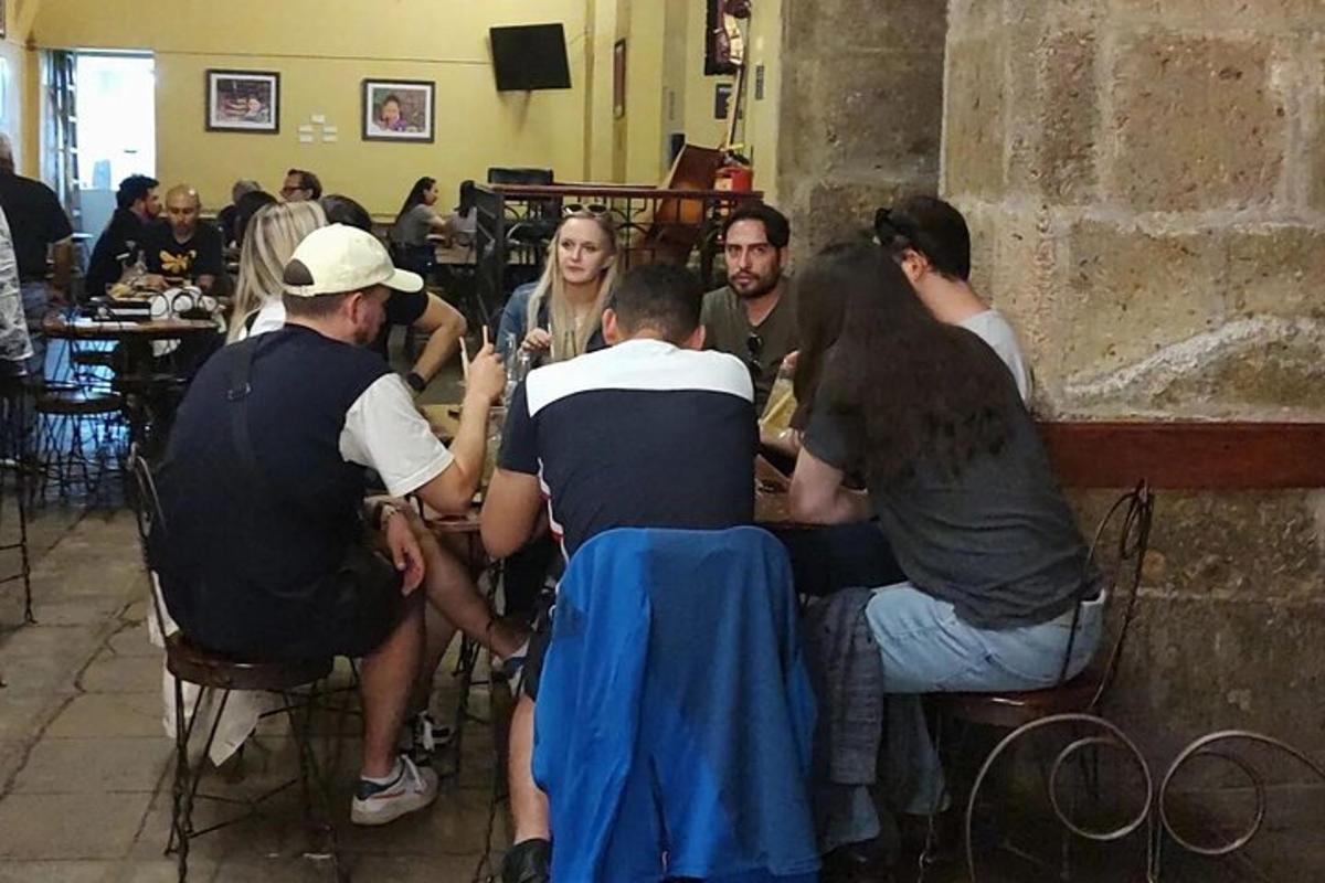μια ομάδα ανθρώπων που κάθονται γύρω από ένα τραπέζι σε ένα εστιατόριο