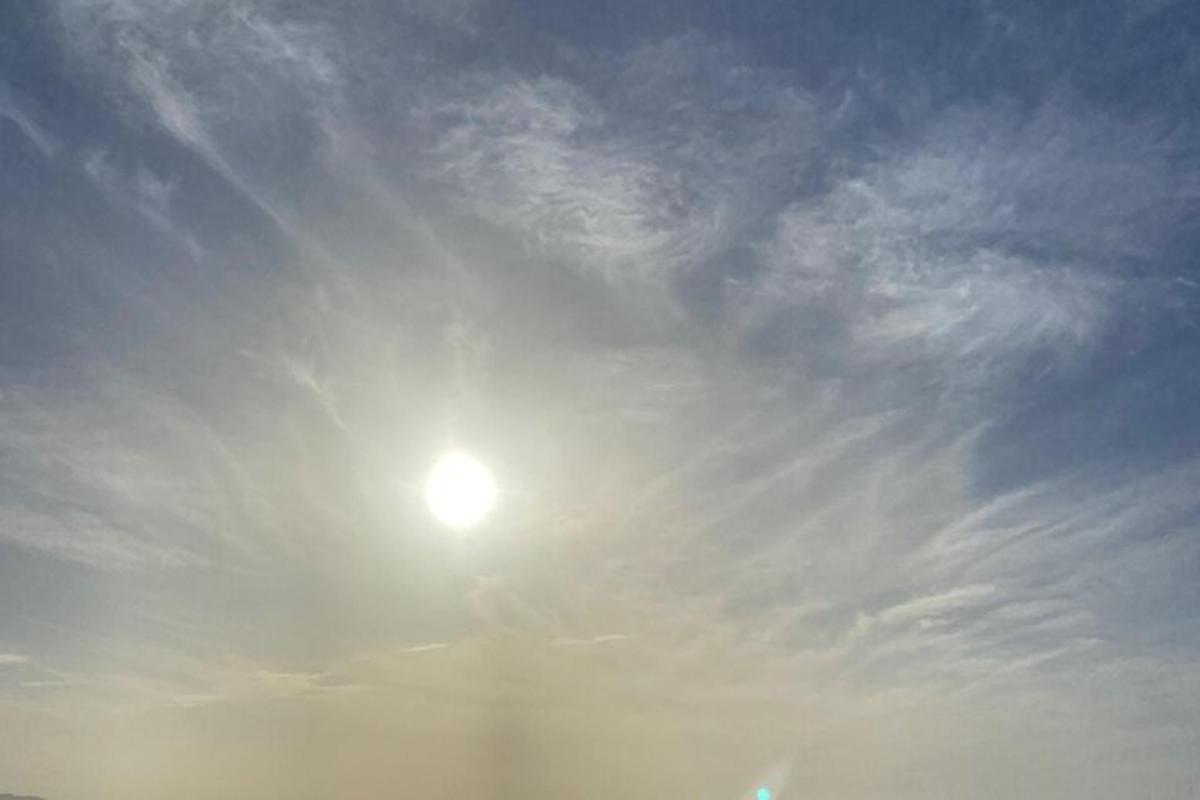 en sol på himlen med en overskyet himmel