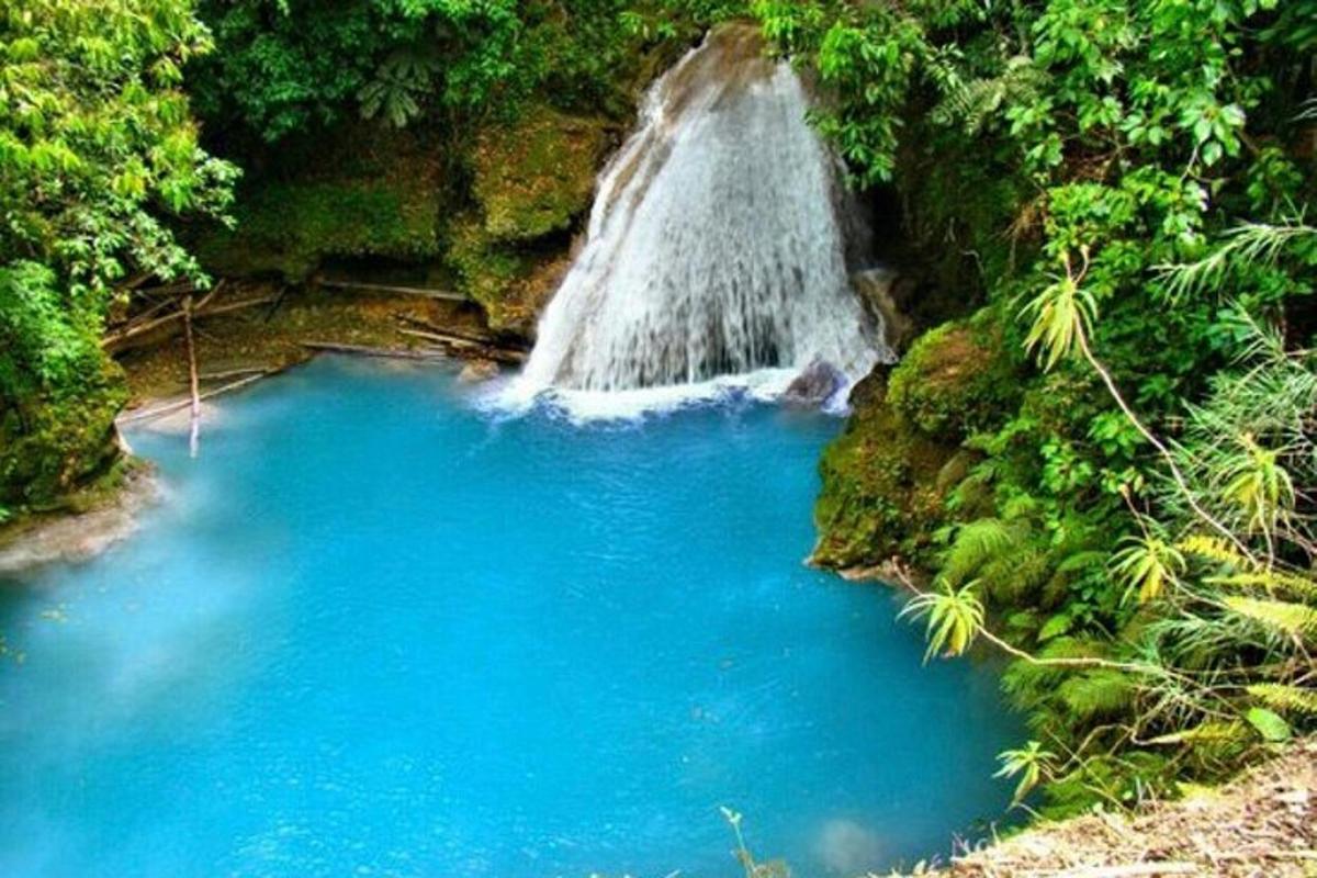 una cascada al mig d'un estany d'aigua blava