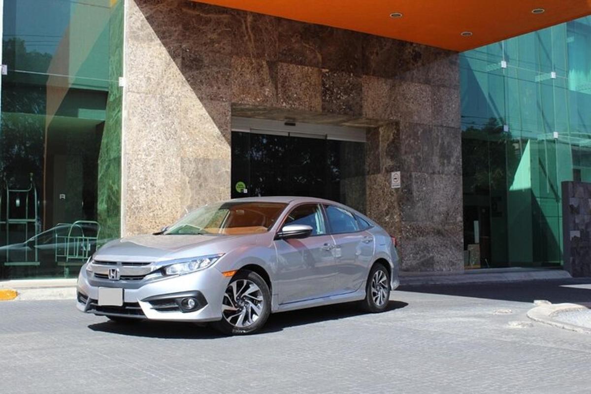 um carro prateado estacionado em frente a um prédio