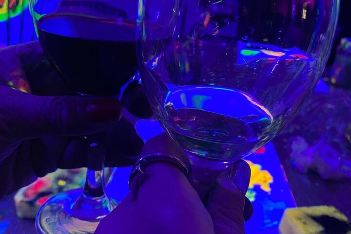 una persona sosteniendo una copa de vino sobre una mesa
