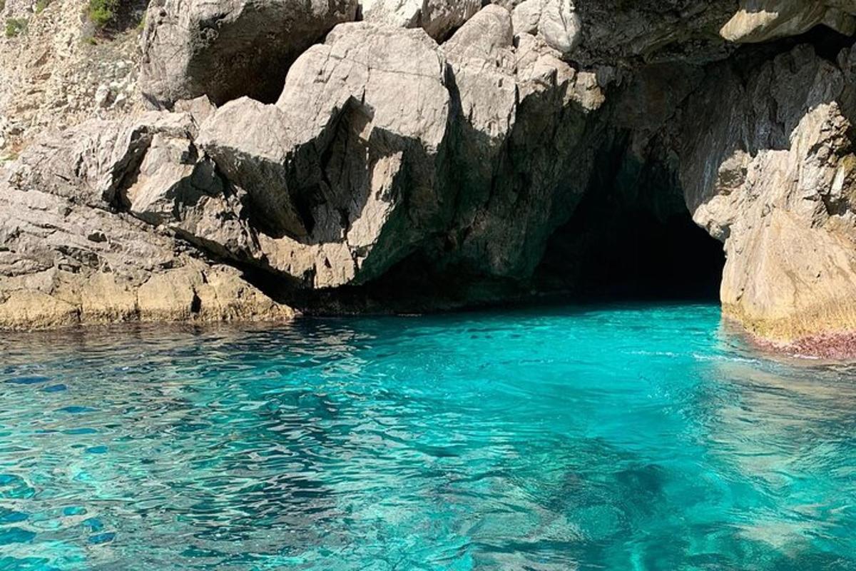 o piscină cu apă albastră lângă o peșteră stâncoasă