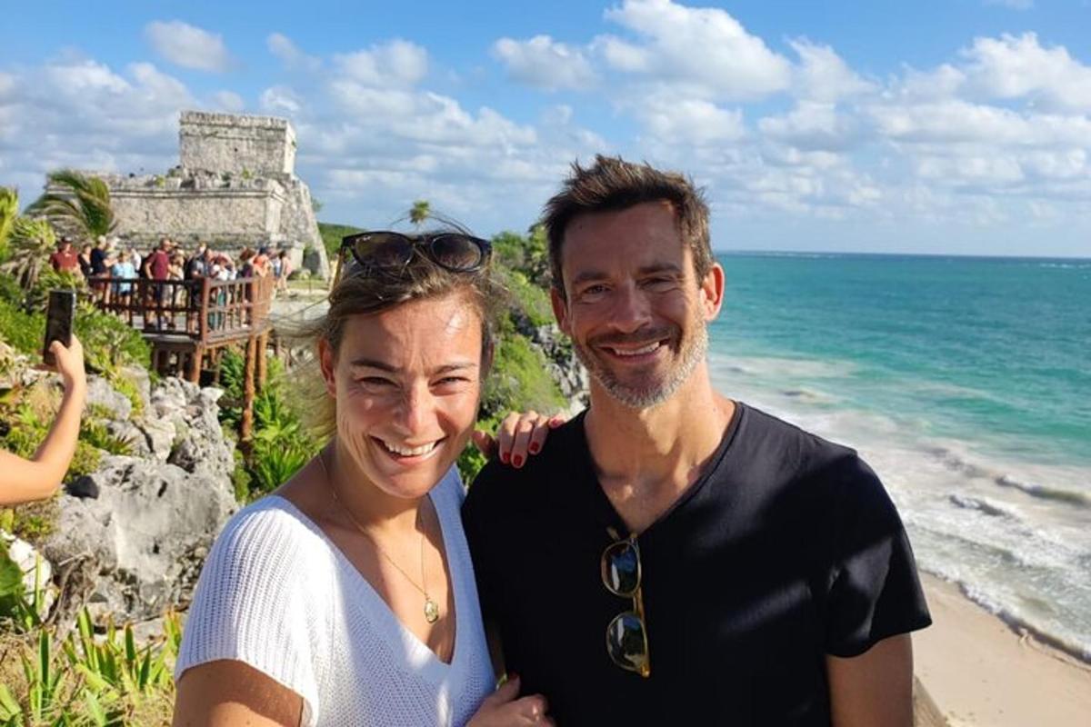 a man and a woman standing next to the ocean