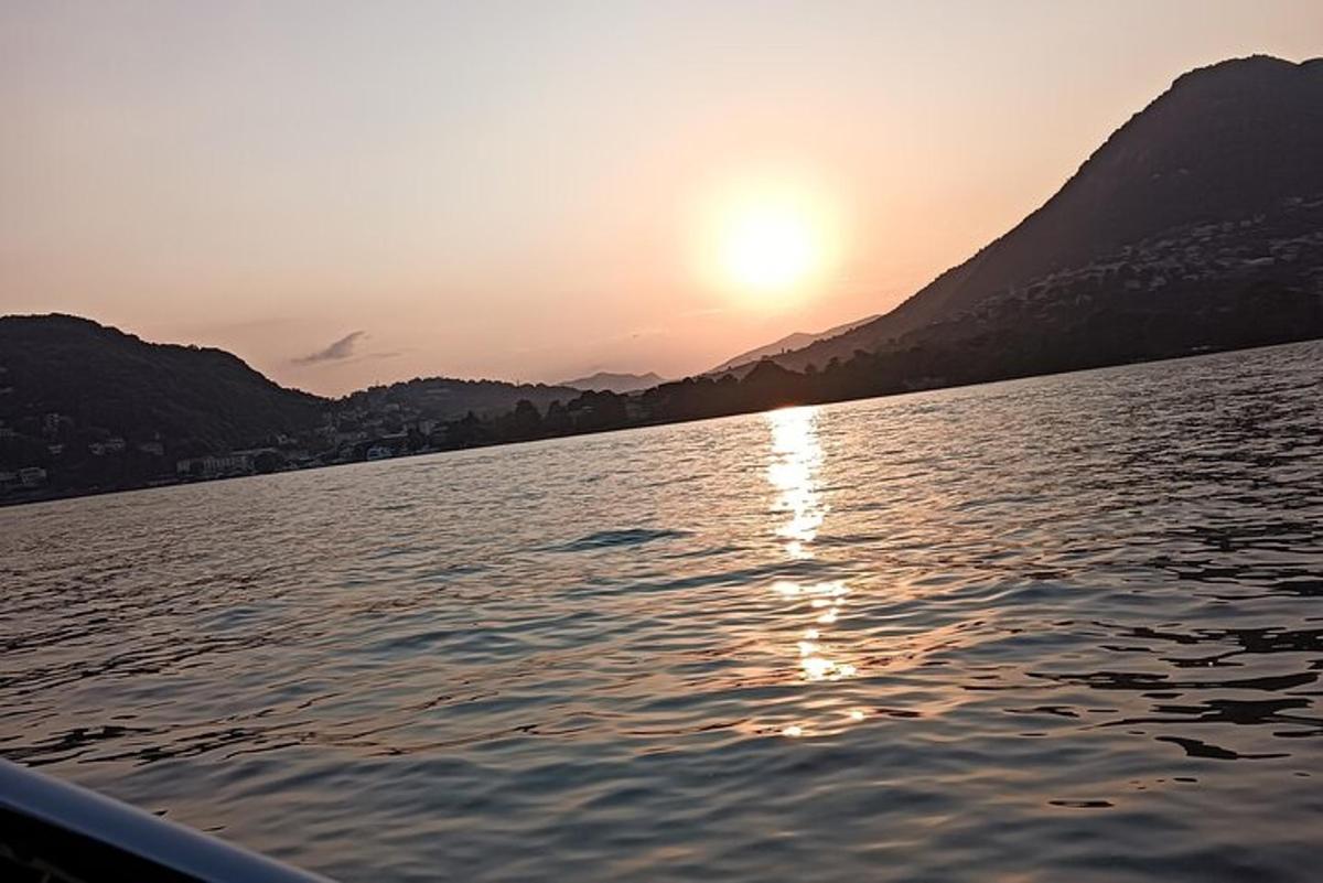 una barca su un lago con il sole che tramonta