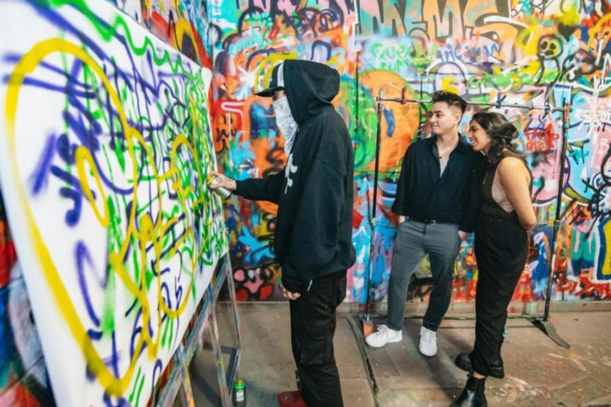a group of people standing in front of a wall with graffiti