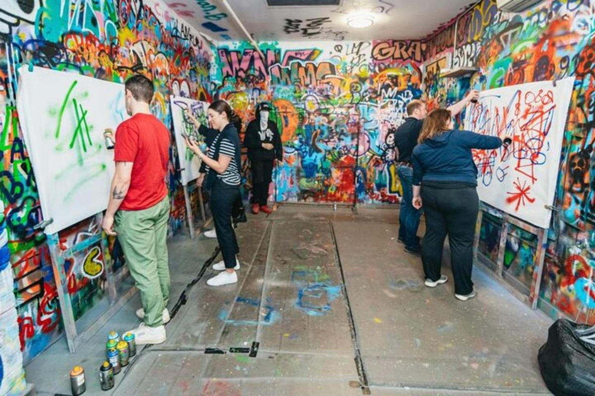 a group of people standing in front of a wall covered in graffiti