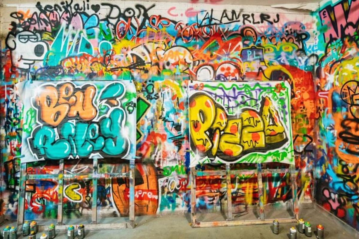 a wall covered in graffiti with paintings on it
