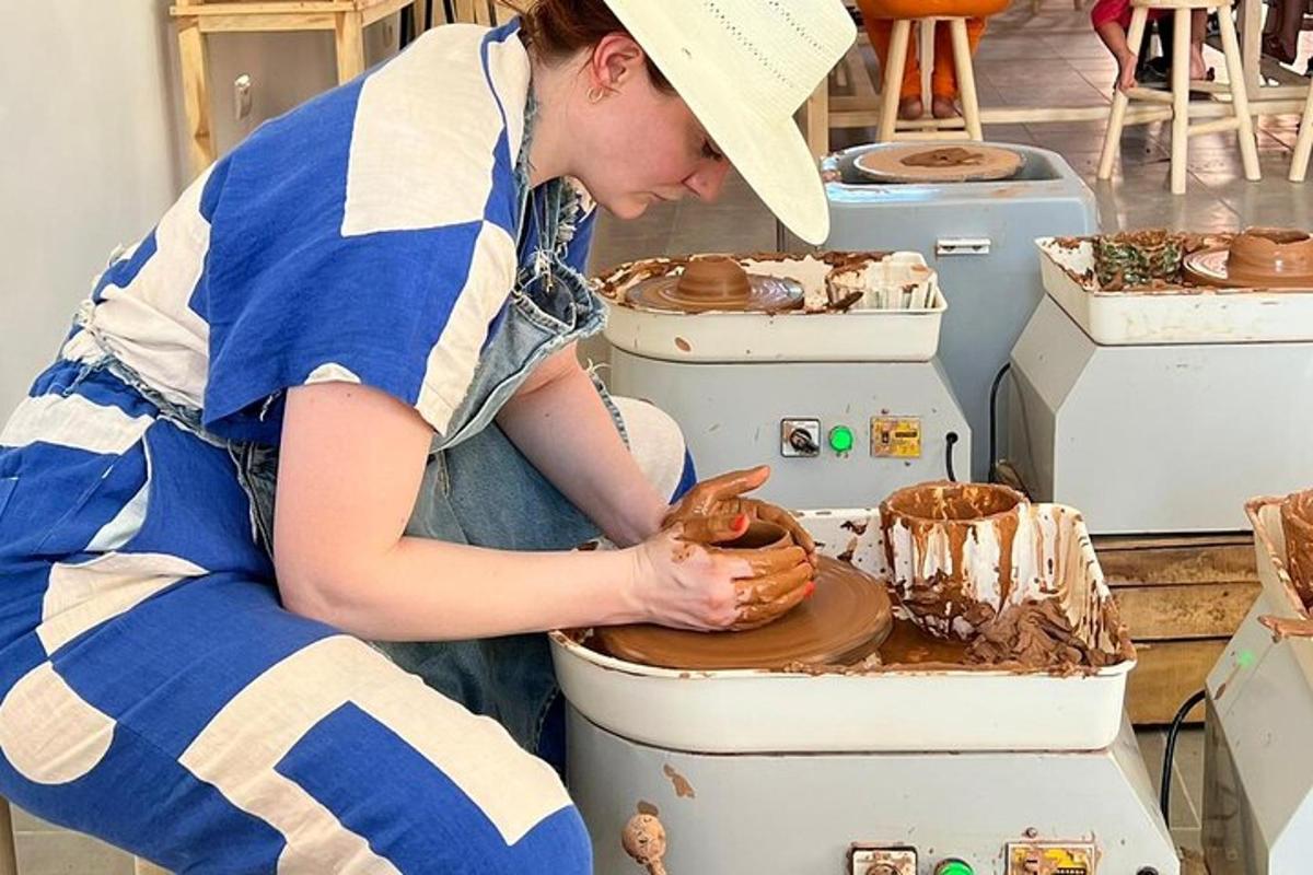 a woman is making a pot on a pottery wheel
