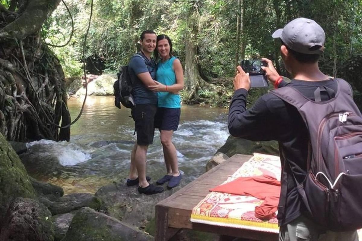 un uomo che scatta una foto a due persone in piedi in un fiume