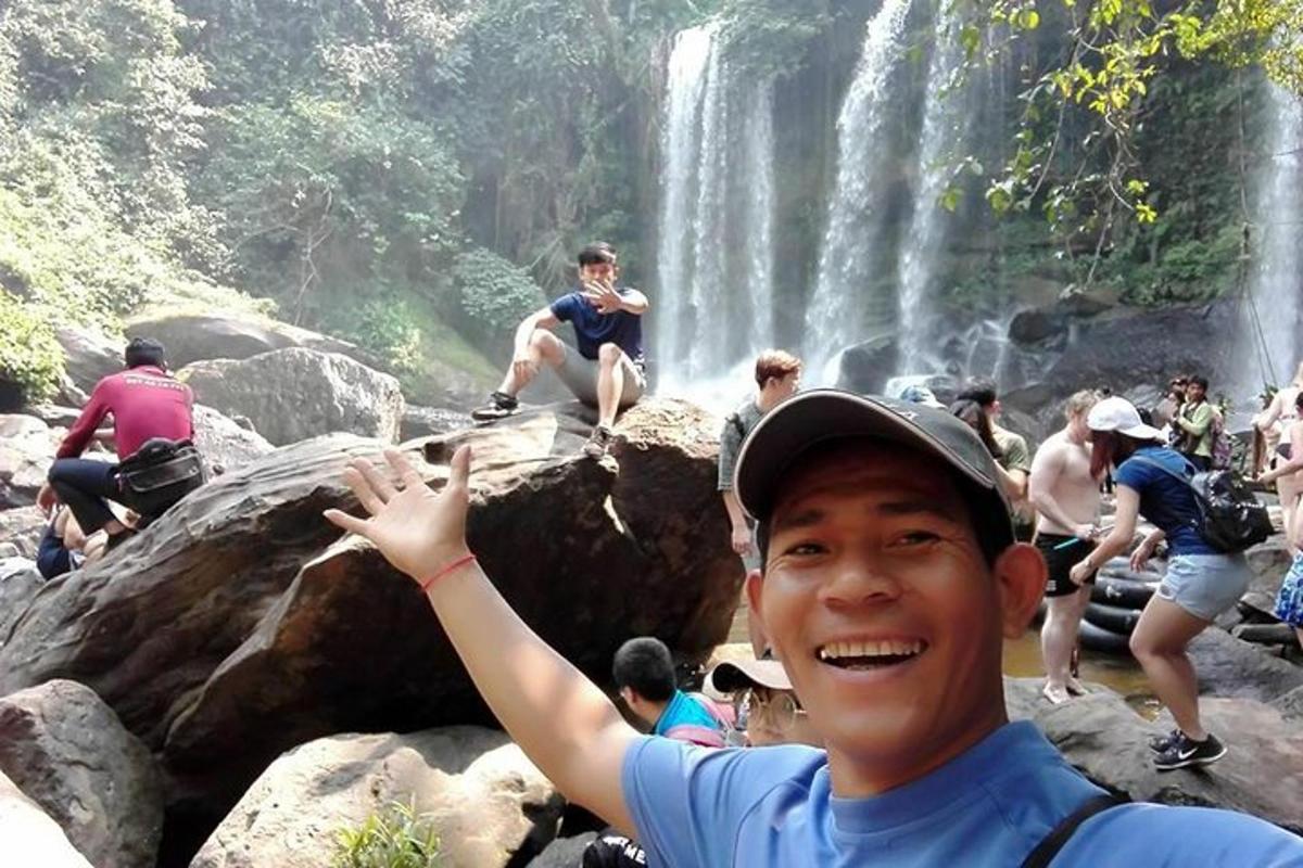 un uomo in piedi davanti a una cascata