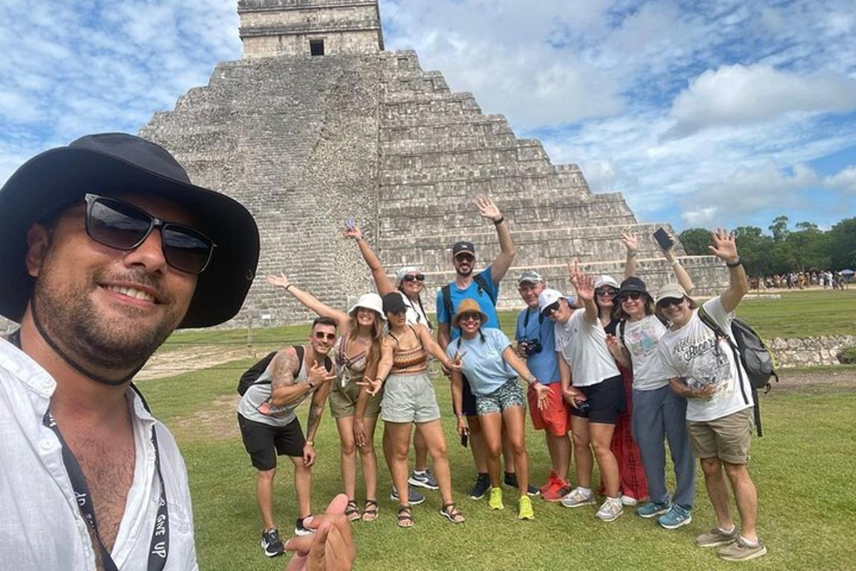 skupina ľudí pózujúcich pred pyramídou