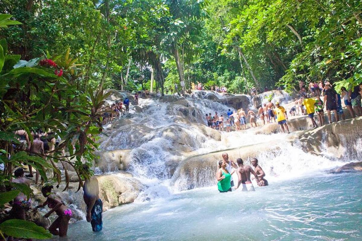 un grup de persones dempeus a l'aigua d'una cascada