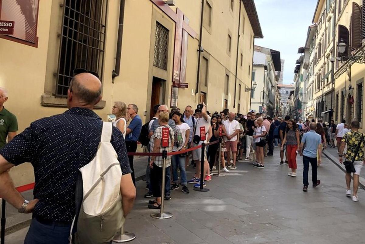 a crowd of people standing in a line in a street