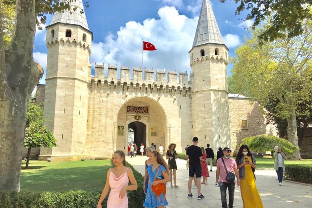 persone che camminano davanti a un castello con una bandiera rossa