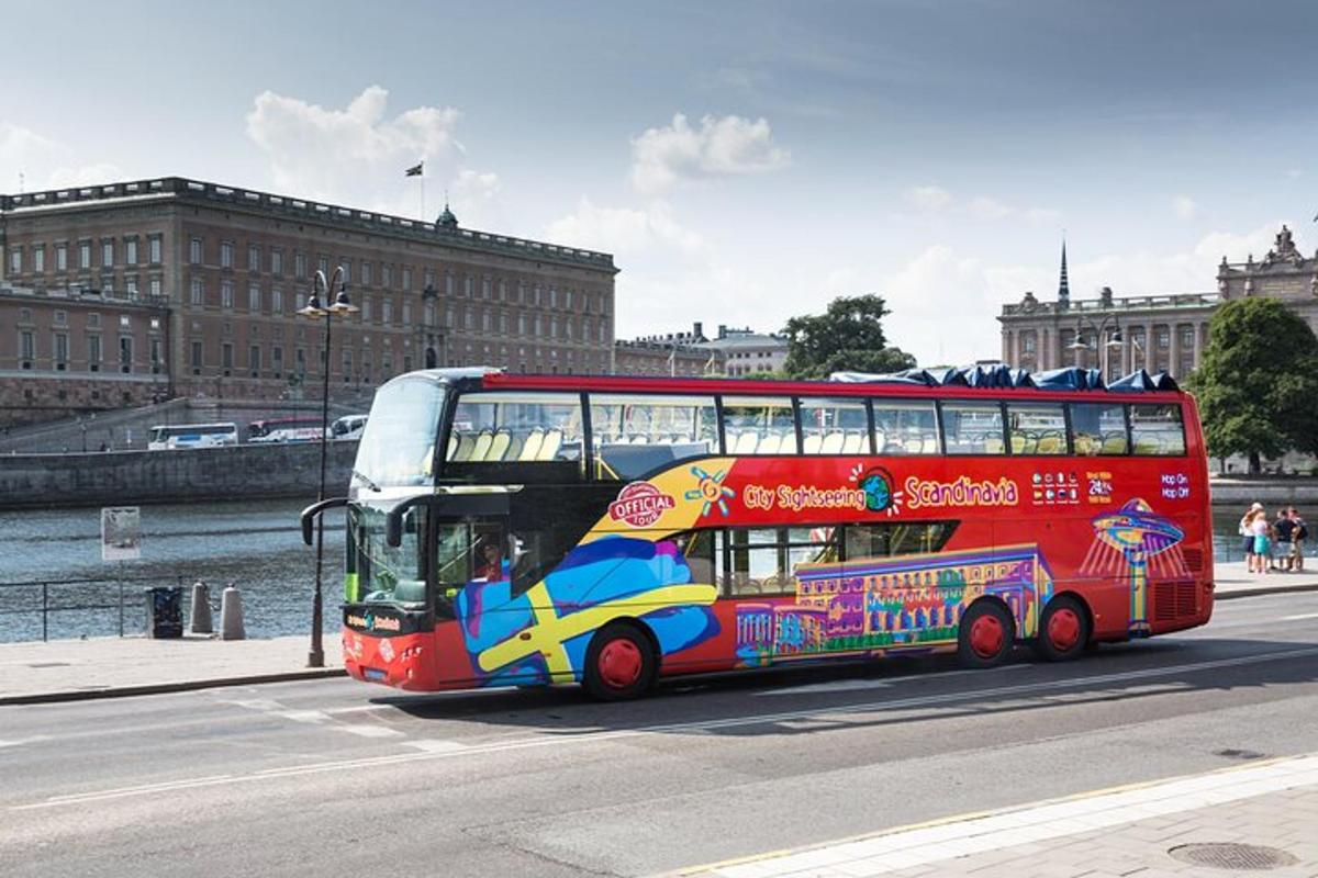 czerwony piętrowy autobus jadący ulicą