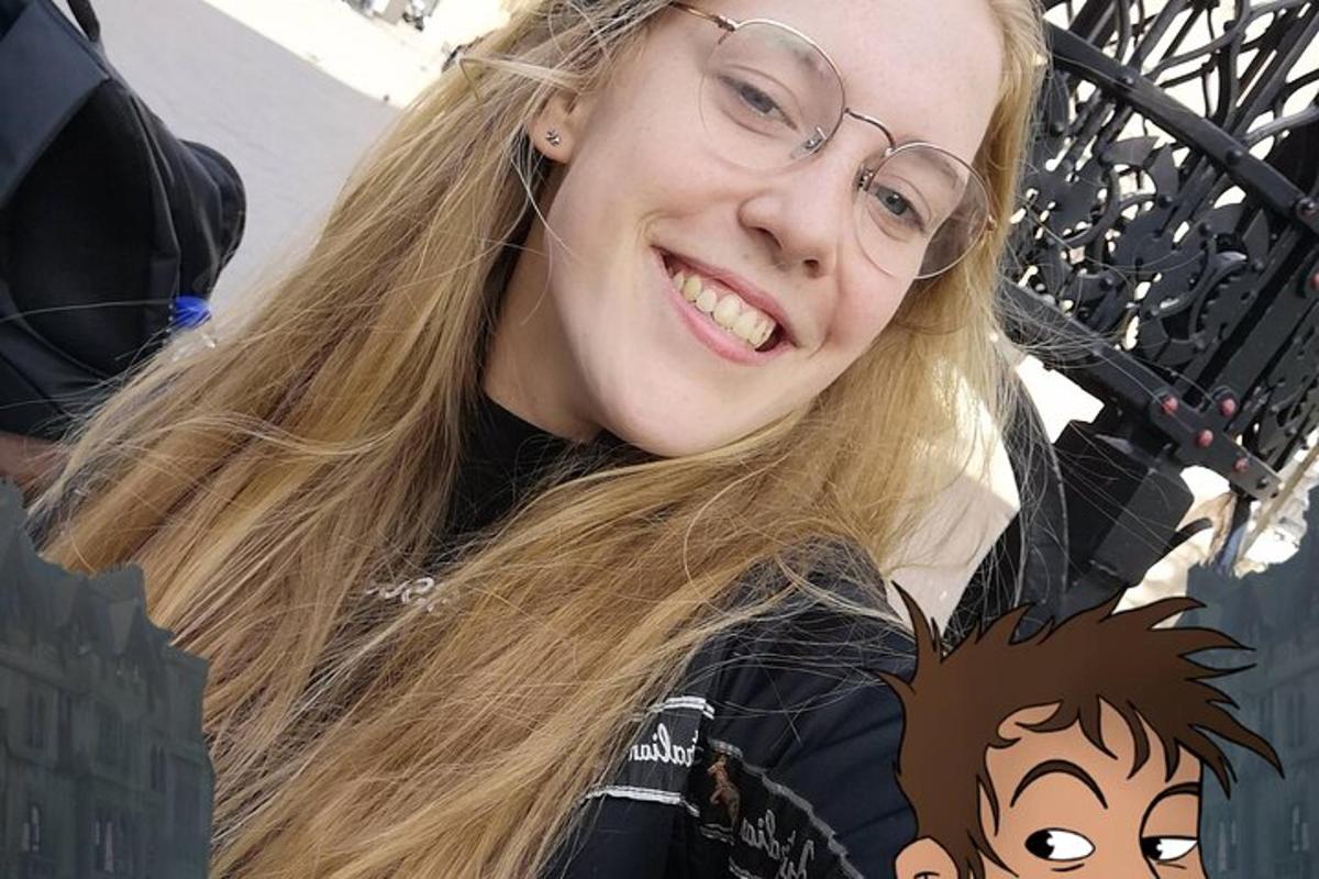 Mladá žena s brýlemi se usmívá do kamery