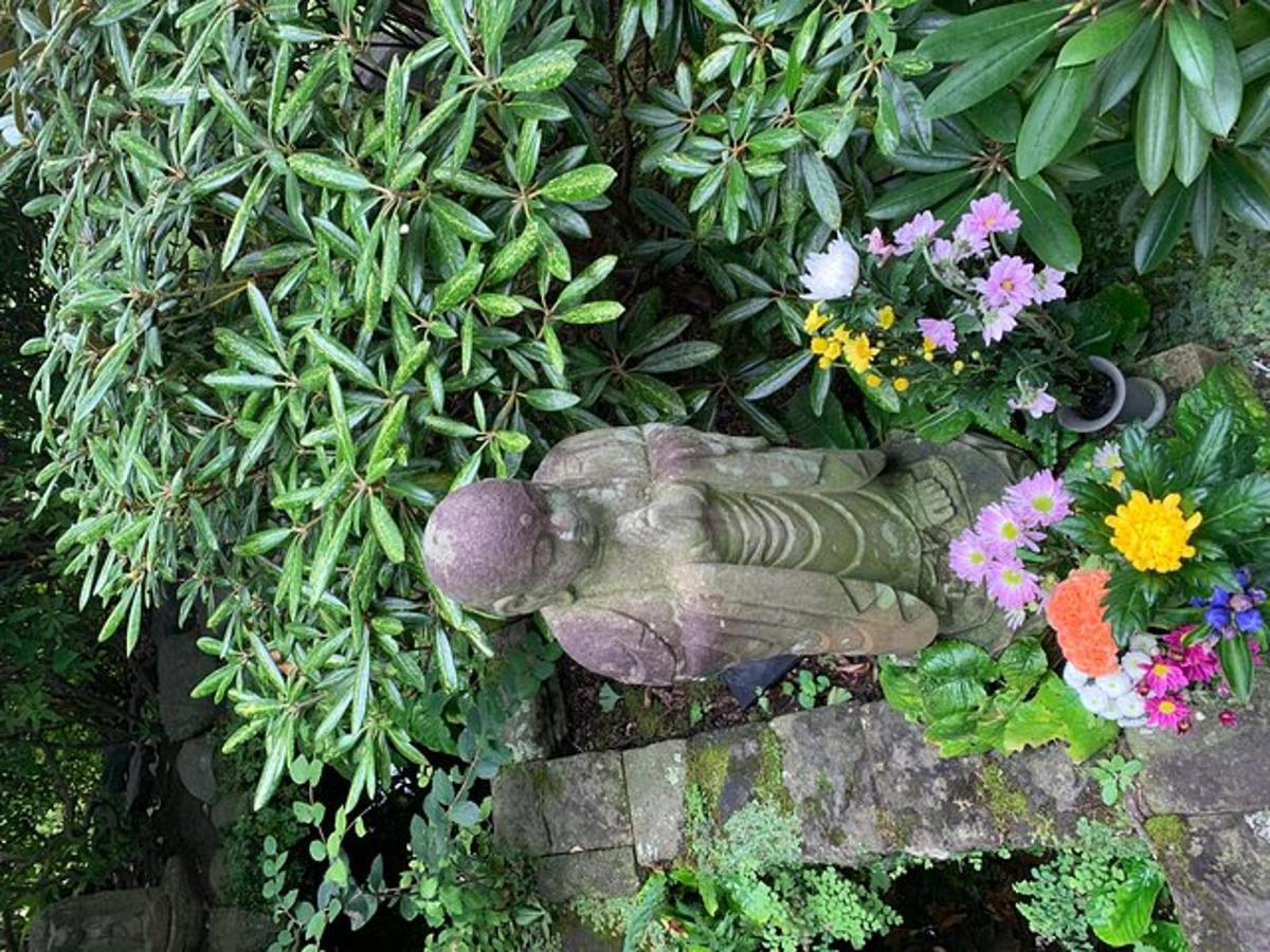 Una estatua de un elefante en un jardín con flores.