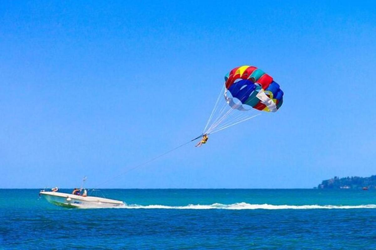 osoba pouštící draka nad lodí v oceánu
