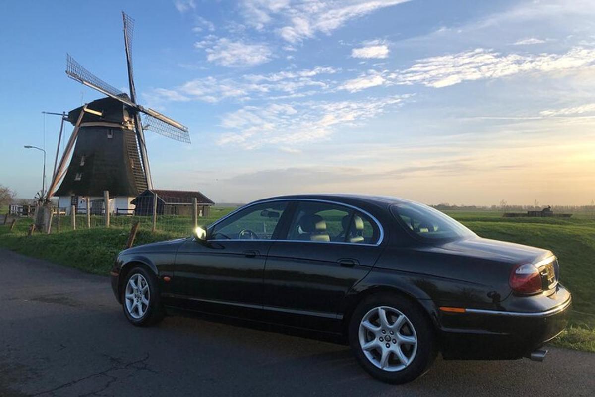 černé auto zaparkované před větrným mlýnem