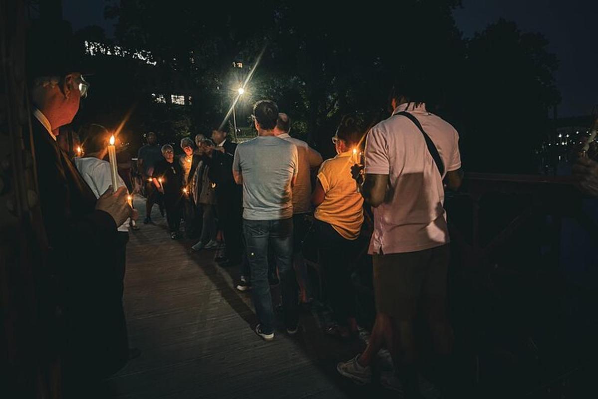 a group of people standing on a sidewalk at night
