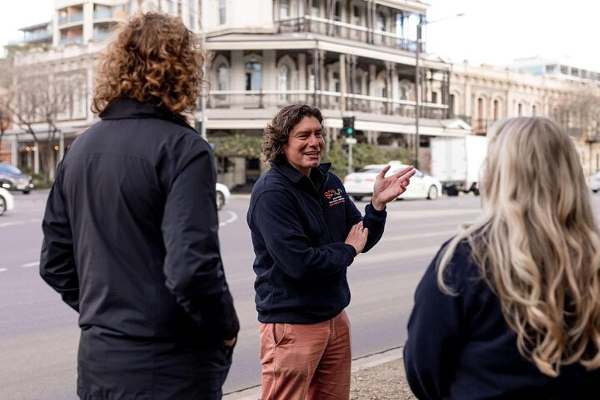 a man talking to two women on a city street