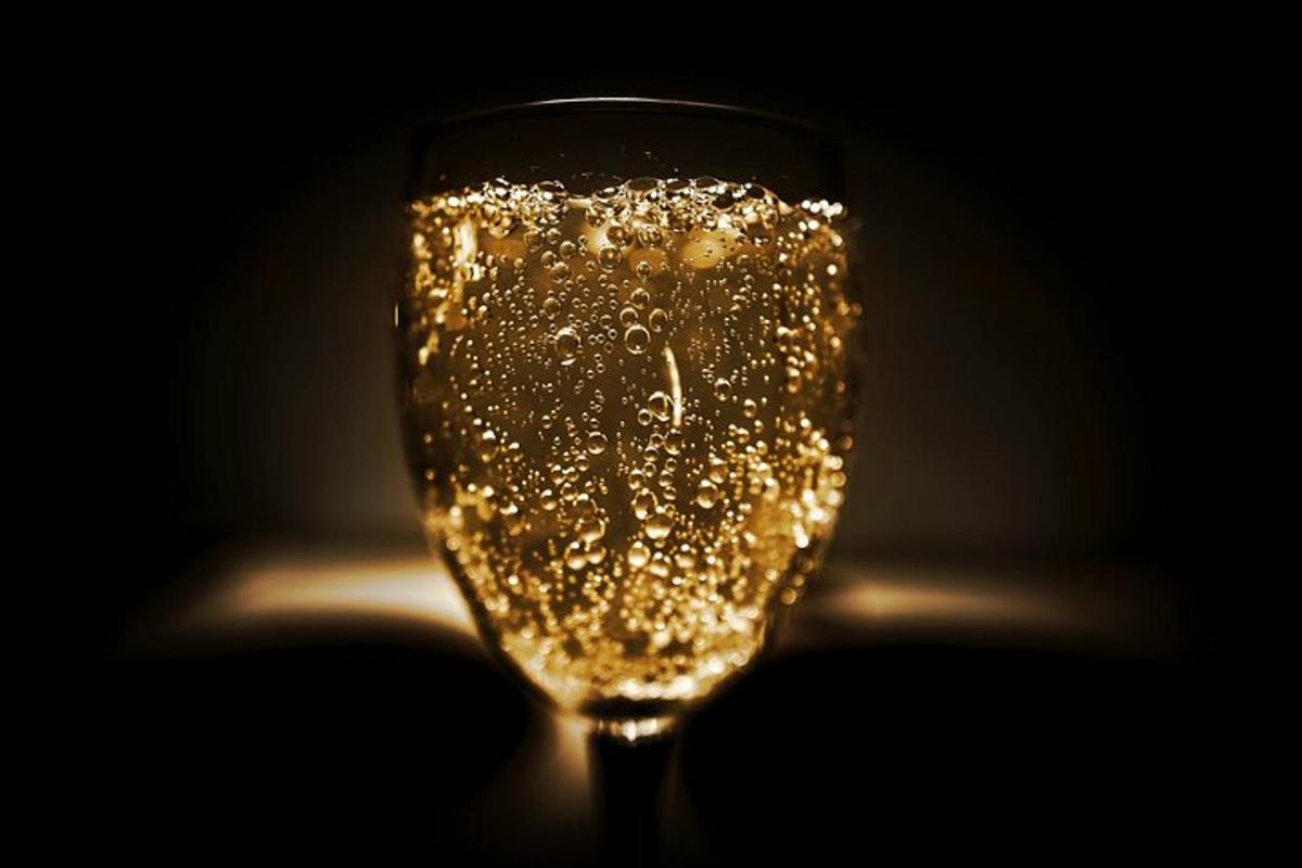 un bicchiere di vino pieno di bollicine in una stanza buia