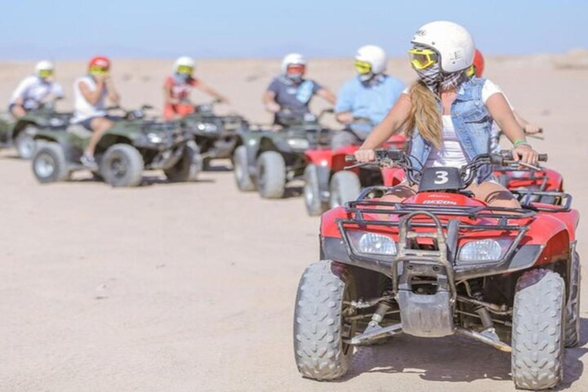 sekumpulan orang menunggang atv di padang pasir