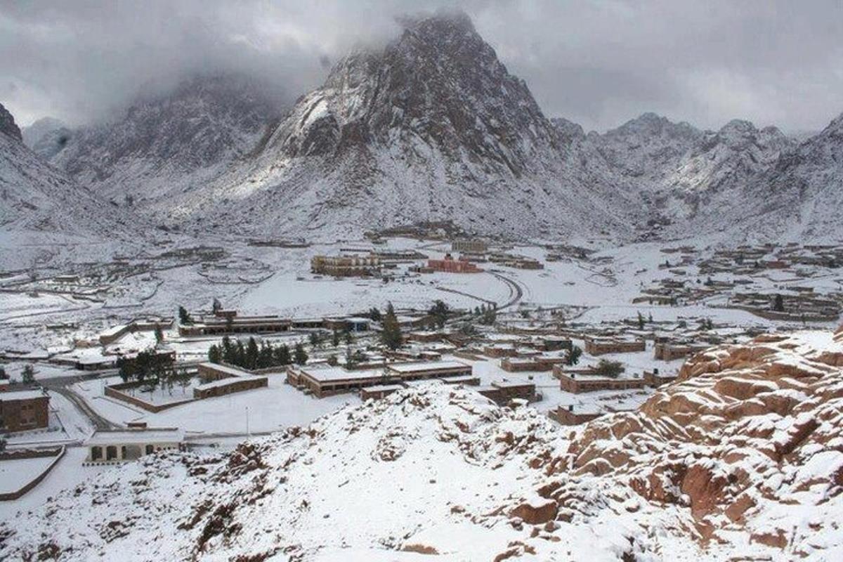 una città coperta di neve di fronte a una montagna